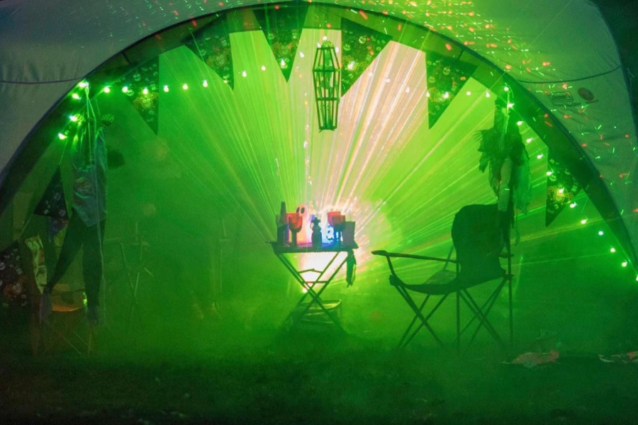 A tent dressed up for Halloween with green lights coming from it