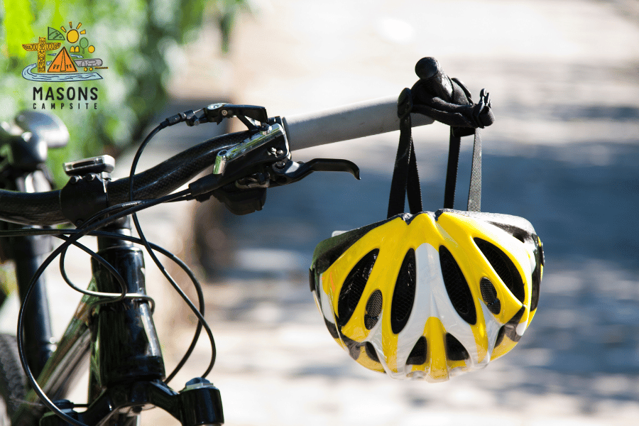 A yellow bicycle helmet hangs from the handle of a bike